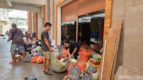 Pedagang pasar Ubud blok barat mulai membuka lapak dagangan mereka sambil menata barang yang sebelumnya sempat dievakuasi, Minggu (18/8/2024). (foto : Putu Krista/detikBali).