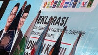 Berjejer logo 12 partai pengusung RK-Suswono. Keduabelas partai itu ialah Gerindra, Golkar, PAN, Demokrat, NasDem, PKB, PKS, Perindo, PSI, PPP, Gelora dan Garuda. Ada tulisan Jakarta Maju di backdrop tersebut.
