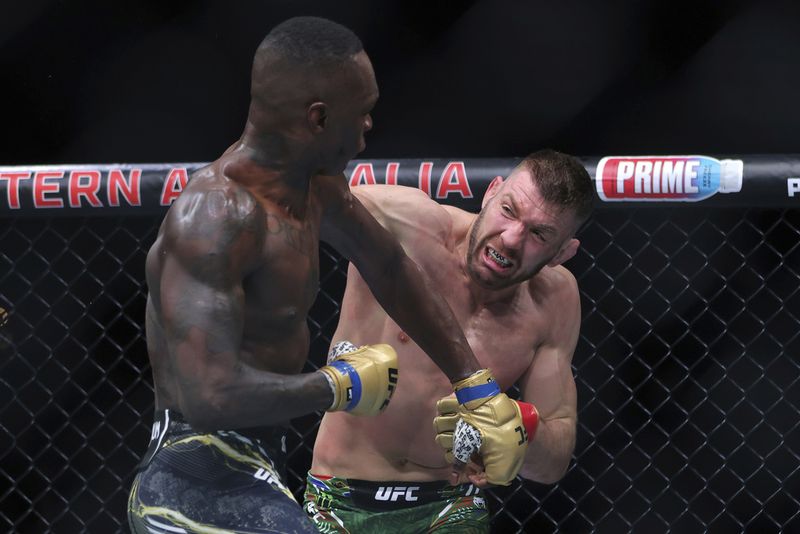 Dricus du Plessis, right, of South Africa and Israel Adesanya of Nigeria fight during their Middleweight title bout at UFC 305 at RAC Arena in Perth, Sunday, Aug. 18, 2024. (Richard Wainwright/AAP Image via AP)