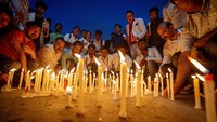 Ribuan orang juga menggelar aksi menyalakan lilin sejak malam hingga Sabtu (17/8) dini hari waktu setempat di Kolkata. Mereka membawa poster berisi protes kepada pemerintah agar memberi perlindungan lebih bagi semua pihak. (AP Photo/Rajesh Kumar Singh) 