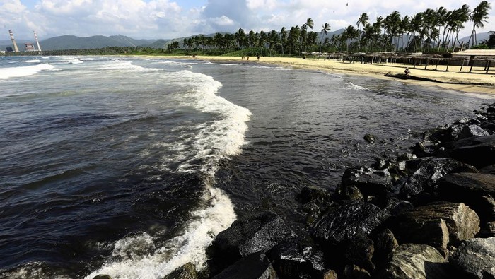 Workers clean the beach after an oil spill, in Boca de Aroa, Venezuela August 16, 2024. REUTERS/Juan Carlos Hernandez