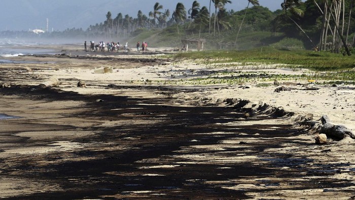 Kilang Minyak di Venezuela Bocor, Laut Jadi Korban Workers clean the beach after an oil spill, in Boca de Aroa, Venezuela August 16, 2024. REUTERS/Juan Carlos Hernandez