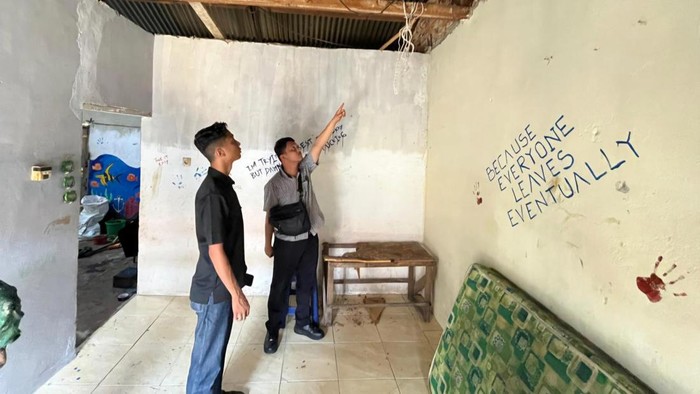 Lokasi penemuan mayat dan tulisan di dinding. (Dok Satreskrim Polres Pelalawan)