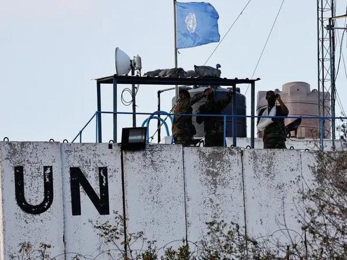 Members of the United Nations peacekeepers (UNIFIL) look at the Lebanese-Israeli border, as they stand on the roof of a watch tower ‏in the town of Marwahin, in southern Lebanon, October 12, 2023. (Reuters)