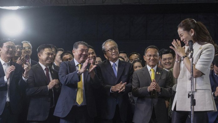 Thailands newly elected Prime Minister Paetongtarn Shinawatra, center right in front, poses  for a selfie with members of her Pheu Thai party, following a press conference at their partys headquarters in Bangkok, Thailand after Thailand’s Parliament elected Paetongtarn  as prime minister Friday, Aug. 16, 2024. (AP Photo/Wason Wanichakorn)