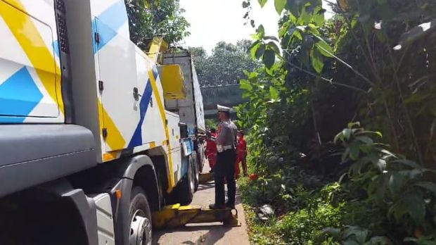 Truk kontainer yang tersangkut di jembatan di Jalan Tapos, Depok, dievakuasi dengan bantuan truk rescue Jasa Marga.