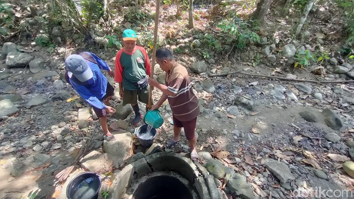 Warga saat mengambil air bersih di galian sumur di sungai kering wilayah Tangkisan 2, Hargomulyo, Kokap, Kulon Progo, Senin (19/8).
