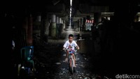 Seorang anak bermain sepeda di kawasan kumuh kolong Tol Wiyoto Wiyono.