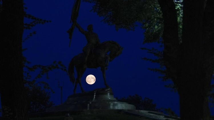 CORRECTS TO JOHN ALEXANDER LOGAN NOT JOHN ALEXANDER MORGAN The moon rises under a monument to John Alexander Logan in Grant Park Sunday, Aug. 18, 2024, in Chicago. (AP Photo/Julio Cortez)