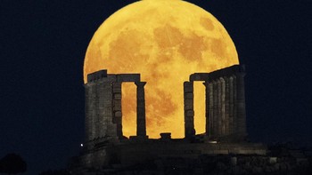 Bulan purnama super muncul di belakang Kuil Poseidon di Tanjung Sounio, sebelah selatan Athena, Senin, 19 Agustus 2024. (AP Photo/Michael Varaklas)  