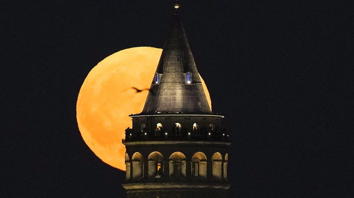 A supermoon rises behind the Galata Tower in Istanbul, Turkey, Monday, Aug. 19, 2024. (AP Photo/Khalil Hamra)