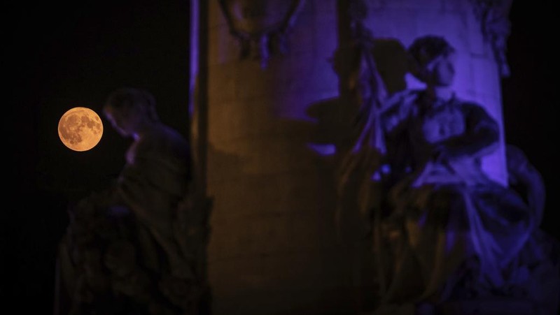 The supermoon appears behind the statue on Place de la République, Monday, Aug. 19, 2024, in Paris. (AP Photo/Aurelien Morissard)