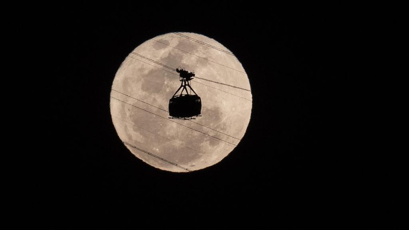 A cable car heads toward Sugarloaf Mountain as the supermoon rises into the night sky in Rio de Janeiro, Monday, Aug 19, 2024. (AP Photo/Bruna Prado)