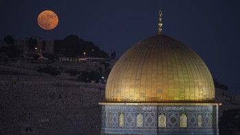 Bulan purnama super muncul di belakang kuil Kubah Batu di kompleks Masjid Al Aqsa di Kota Tua Yerusalem, Senin, 19 Agustus 2024.  (AP Photo/Leo Correa)  