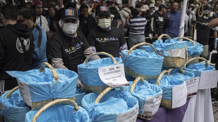 Taco vendors stand behind their baskets during a record-breaking event for the most tacos served in one hour — 30,000 — at the Angel of Independence monument in Mexico City, Sunday, Aug. 11, 2024. (AP Photo/Aurea del Rosario)