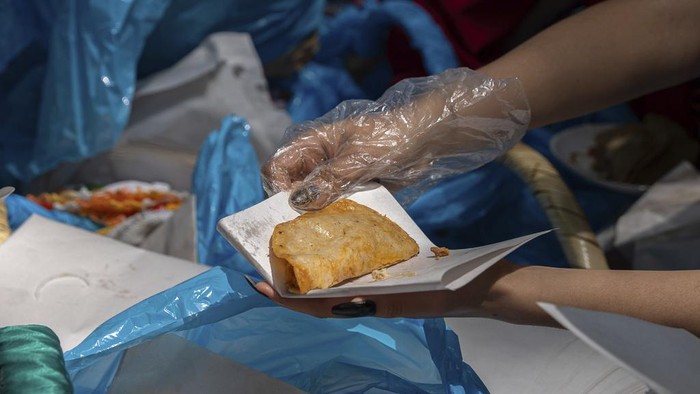 Taco vendors stand behind their baskets during a record-breaking event for the most tacos served in one hour — 30,000 — at the Angel of Independence monument in Mexico City, Sunday, Aug. 11, 2024. (AP Photo/Aurea del Rosario)