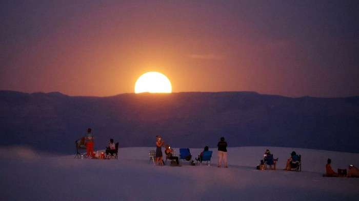 Memandang Supermoon dari Gurun Pasir Putih Terluas di Dunia People gather to watch the Supermoon, known as the blue moon and