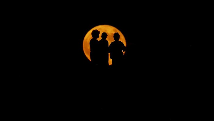People gather to watch the Supermoon, known as the blue moon and 