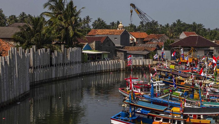 Sejumlah kapal bersandar di dekat pembangunan dinding turap di Sungai Cipunten Agung, Kabupaten Pandeglang, Banten, Senin (19/8/2024). Dinas Pekerjaan Umum dan Penataan Ruang (DPUPR) Provinsi Banten memasang dinding penahan (turap) sepanjang 243 meter di sisi Sungai Cipunten Agung dengan anggaran APBD Tahun 2024 sebesar Rp5,5 miliar yang bertujuan untuk meminimalkan potensi banjir akibat luapan air dari sungai. ANTARA FOTO/Angga Budhiyanto/gp/YU