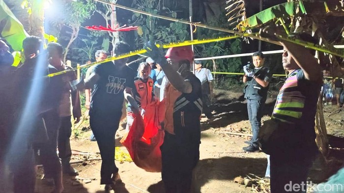 Petugas melakukan olah TKP penemuan mayat pria dengan luka bekas sabetan senjata tajam di pekarangan rumah warga Desa Jogoboyo, Kecamatan Purwodadi, Purworejo, Selasa (20/8/2024) malam.