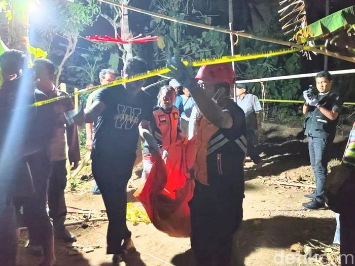 Petugas melakukan olah TKP penemuan mayat pria dengan luka bekas sabetan senjata tajam di pekarangan rumah warga Desa Jogoboyo, Kecamatan Purwodadi, Purworejo, Selasa (20/8/2024) malam.