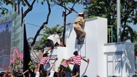 Aksi teatrikal perobekan bendera turut mewarnai peringatan Hari Juang Polri di Surabaya (Foto: Esti Widiyana/detikJatim)
