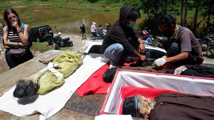 Warga mengangkat jenazah keluarganya saat ritual Ma'nene Suku Toraja di Lembang Maiting, Kecamatan Rindingallo, Kabupaten Toraja Utara, Sulawesi Selatan, Selasa (20/8/2024). Ritual Ma'nene atau pergantian pakaian jenazah tersebut telah dilakukan turun temurun oleh masyarakat Suku Toraja dan saat ini Pemda setempat mempromosikan budaya itu untuk menarik kunjungan wisatawan. ANTARA FOTO/Sakti Karuru/nym.