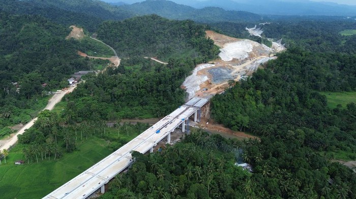 Foto udara lanjutan pembangunan jalan tol di Nagari Kapalo Hilalang, Padang Pariaman, Sumatera Barat, Rabu (21/8/2024). Akses jalan nasional Padang - Bukittinggi di Nagari Kapalo Hilalang akan mengalami pelambatan dan buka tutup arus lalu-lintas karena adanya pengerjaan pemasangan balok Erection Girder pada jembatan jalan tol Padang-Sicincin di wilayah tersebut hingga 22 Agustus 2024. ANTARA FOTO/Iggoy el Fitra/aww.