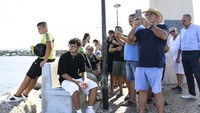 Warga dan wartawan menyaksikan proses pencarian korban hilang dari insiden tenggelamnya kapal tersebut. (AP Photo/Salvatore Cavalli)