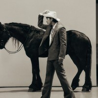 Dalam foto lain, Gong Yoo berpose dengan kuda sungguhan. Dia tampil manly memegang koleksi Palm Tree Material Cowboy Silhouette Lasso Hat seharga 1,9 juta won atau Rp 22 juta. Foto: dok. GQ Korea