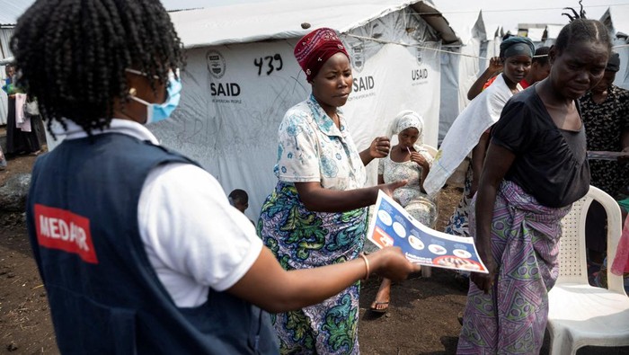 Nathalie Kipenzi, a hygiene promoter, distributes flyers to displaced people during an awareness campaign for Mpox, an infectious disease caused by the monkeypox virus that causes a painful rash, enlarged lymph nodes and fever, at the Muja camp for the internally displaced in Nyiragongo territory, near Goma in North Kivu province of the Democratic Republic of Congo August 19, 2024. REUTERS/Arlette Bashizi