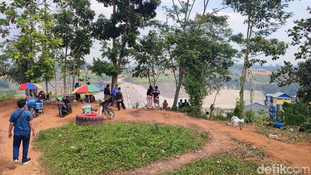 Sejumlah warga mengunjungi sisi Bendungan Leuwikeris di wilayah Ciamis sebagai tempat wisata dadakan. Mereka foto-foto sambil botram.