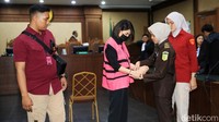 Petugas kejaksaan juga memborgol tangan Helena. 