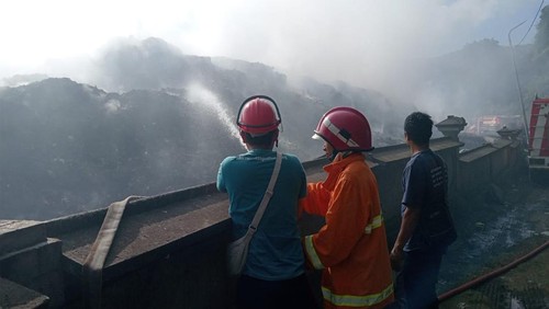 Upaya pemadaman api kebakaran TPA Sente dengan kondisi asap pekat masuk hingga pemukiman warga, Rabu (21/8/2024). (Putu Krista/detikBali)