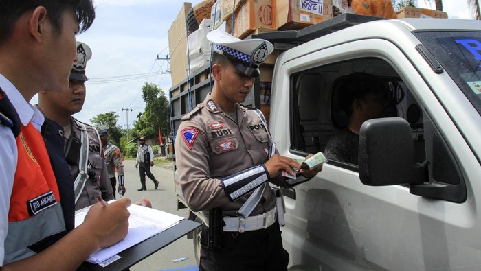 Ada Razia Kendaraan ODOL di Papua, Begini Potretnya! Polisi dan petugas Dinas Perhubungan Kota Jayapura memeriksa surat kendaran angkutan barang saat operasi pengawasan dan penindakan kendaraan over load over dimension(ODOL) di Jalam Raya Waena Sentani, Kota Jayapura, Papua, Kamis (22/08/2024). Operasi gabungan Dishub Kota Jayapura bersama Satlantas Polresta Jayapura tersebut guna menertibkan kendaraan yang berat muatannya berlebih agar sesuai dengan peraturan lalu lintas yang berlaku sebagai upaya menjaga keamanan, kenyamanan, serta keselamatan di jalan raya. ANTARA FOTO/Gusti Tanati/tom.