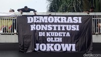 Massa membentangkan berbagai poster berisi sentilan untuk Presiden Jokowi.