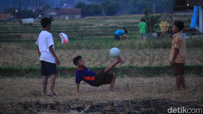 Bermain sepakbola di lapangan jerami