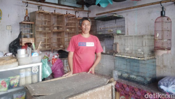 Budi Kipli di depan toko burung miliknya