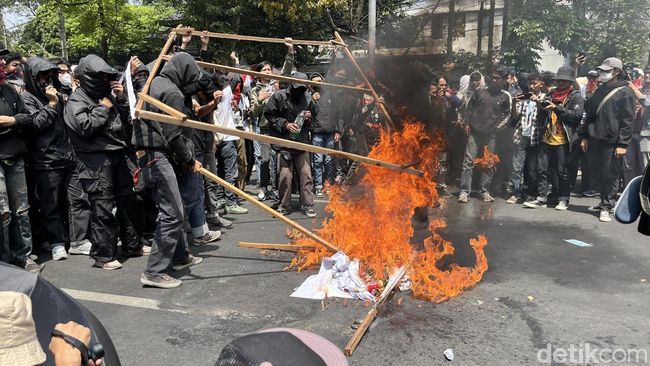 Demonstran bakar baliho partai.
