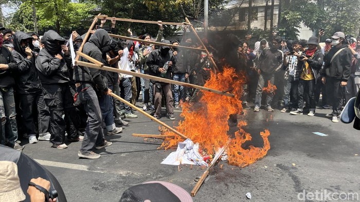 Demonstran bakar baliho partai.
