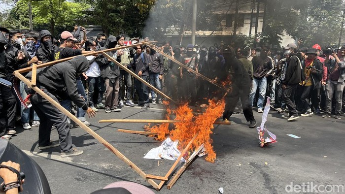 Demonstran bakar baliho partai.