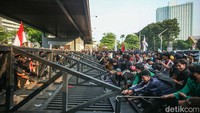 Massa pun membentangkan bendera institusi kampus dan bendera Merah Putih.  