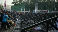 Massa aksi yang menolak pengesahan revisi Undang-Undang (UU) Pilkada merobohkan gerbang pintu masuk belakang atau Gerbang Pancasila Gedung MPR/DPR/DPD RI, Senayan, Jakarta.  