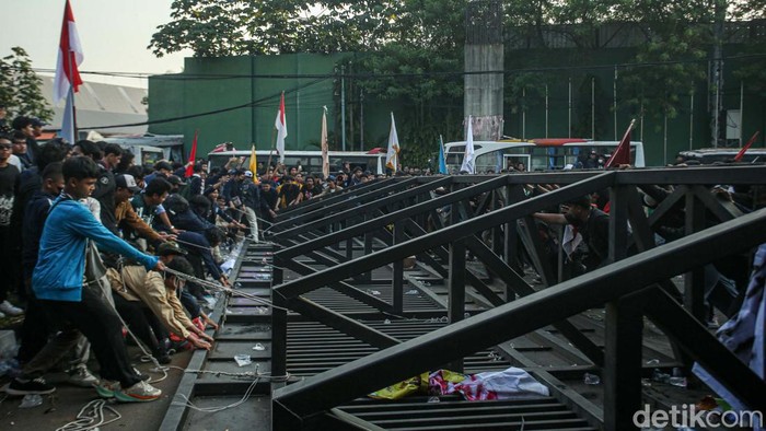 Detik-detik Pintu Gerbang Belakang DPR Roboh Massa aksi yang menolak pengesahan revisi UU Pilkada juga beraksi di pintu masuk belakang atau Gerbang Pancasila. Mereka berhasil merobohkan pintu gerbang.