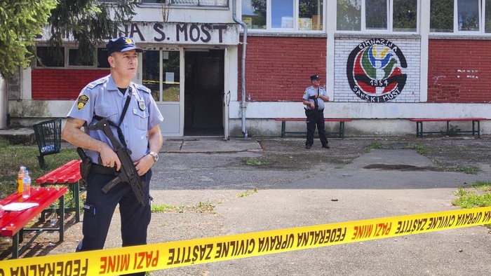 Police officers stand in front of a secondary school building in Sanski Most, northwest of Bosnia's capital, Sarajevo, Wednesday, Aug. 21, 2024, after a school employee shot and killed three people. (AP Photo/Edvin Zulic)