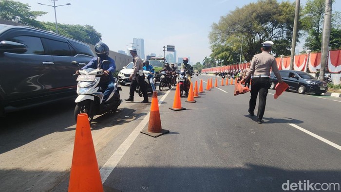 Jalan Gatsu Depan DPR Ditutup, Kendaraan Diarahkan ke Busway Polisi menutup jalan di depan Gedung DPR RI, Gatot Subroto, Jakarta, Kamis (22/8/2024).