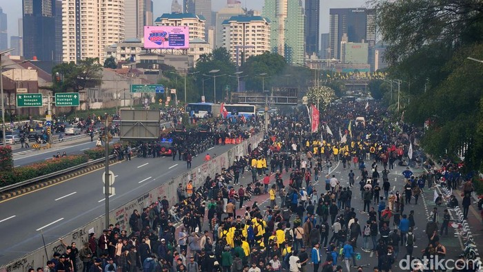 Massa yang menggelar demonstrasi di depan gedung DPR, Jalan Gatot Subroto, Jakarta Pusat, menerobos jalan Tol Dalam Kota. Arus lalu lintas di dalam tol pun terhenti.