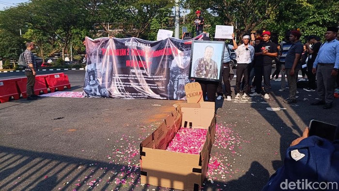 Massa melakukan aksi tabur bunga di halaman Mapolda Jateng, Semarang, untuk memperingati 2 tahun kasus mutilasi ASN Semarang, Iwan Boedi Prasetijo, Kamis (22/8/2024).