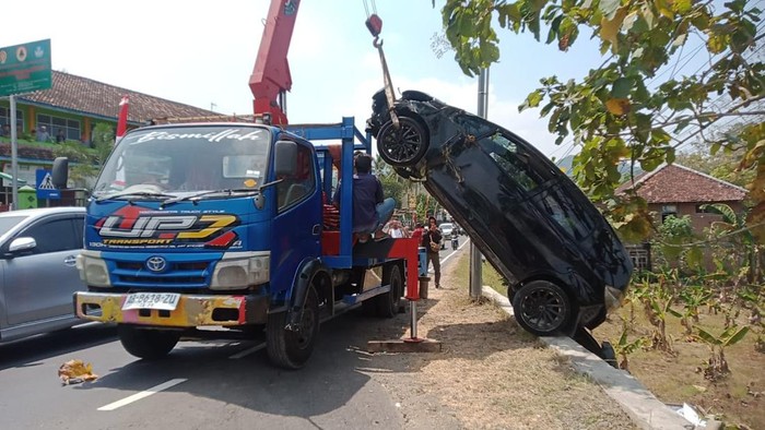 Polisi menderek mobil Honda Jazz AB 1359 SD yang masuk parit di tikungan Tri Sakti, Patuk, Gunungkidul, DIY, Kamis (22/8/2024).