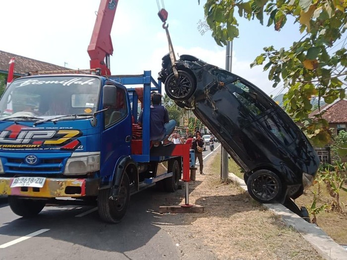 Polisi menderek mobil Honda Jazz AB 1359 SD yang masuk parit di tikungan Tri Sakti, Patuk, Gunungkidul, DIY, Kamis (22/8/2024).